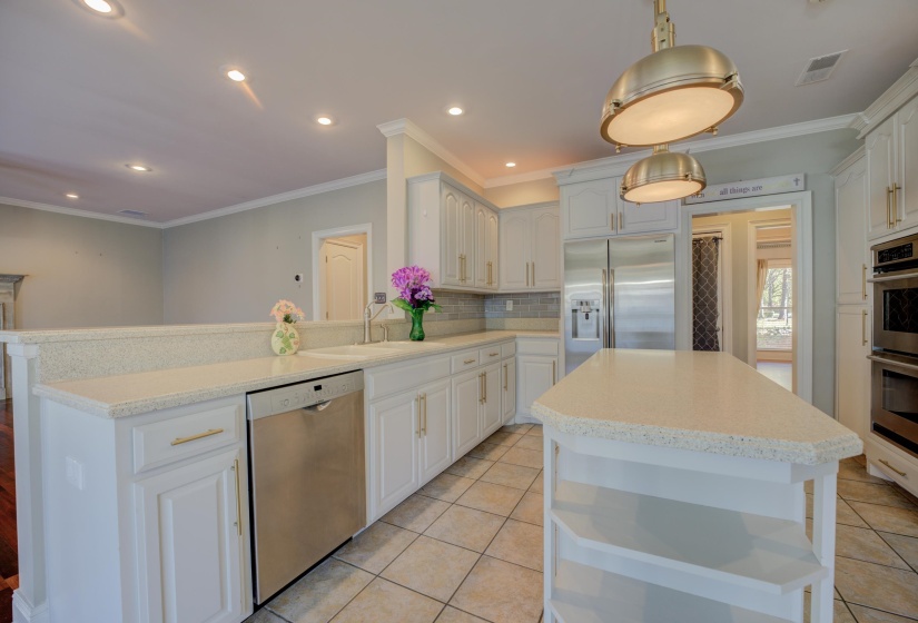 Kitchen with appliances with stainless steel finishes, tasteful backsplash, white cabinetry, and pendant lighting
