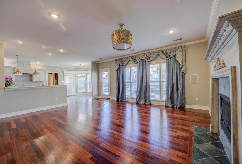 Unfurnished living room featuring a fireplace, dark hardwood / wood-style flooring, and crown molding