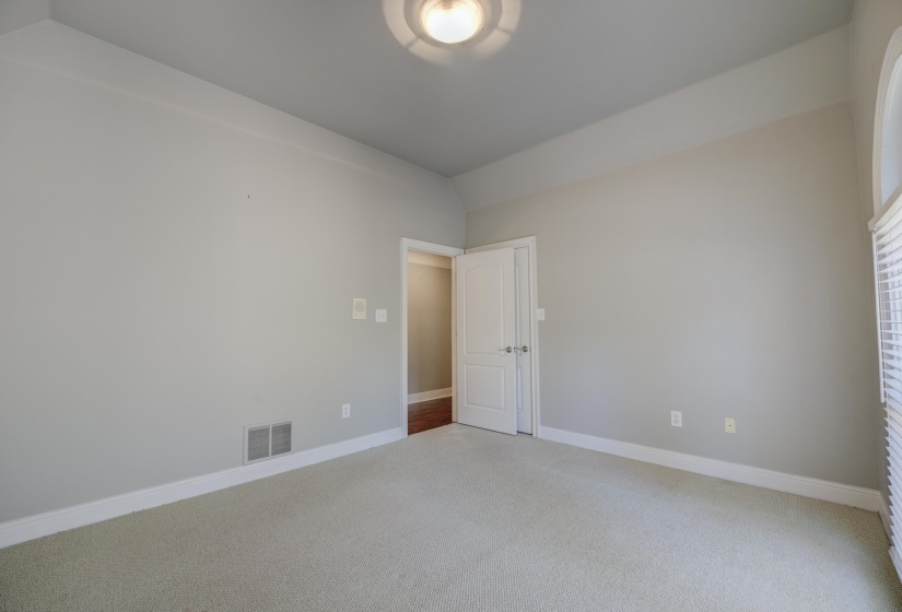 Spare room featuring lofted ceiling and carpet floors