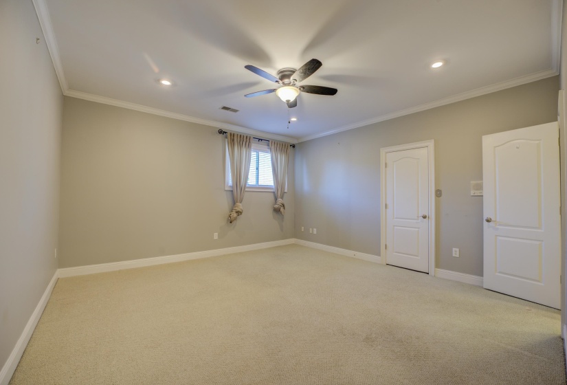 Carpeted empty room with ceiling fan and crown molding
