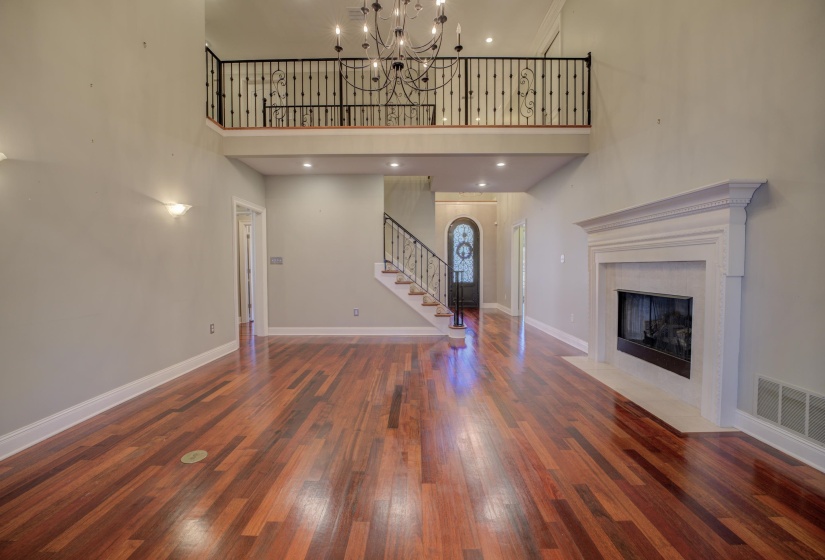 Unfurnished living room with a tile fireplace, a towering ceiling, and dark hardwood / wood-style floors