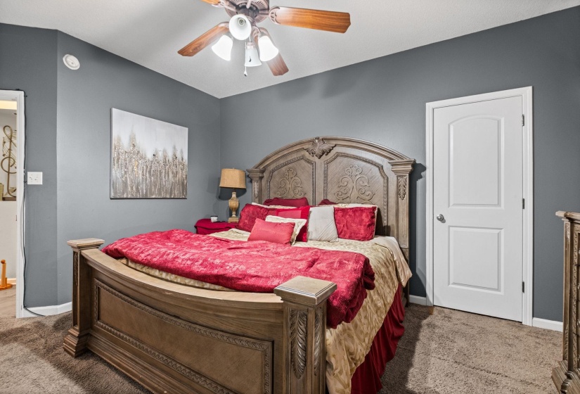 Bedroom featuring neutral carpeting and a ceiling fan with integrated lighting