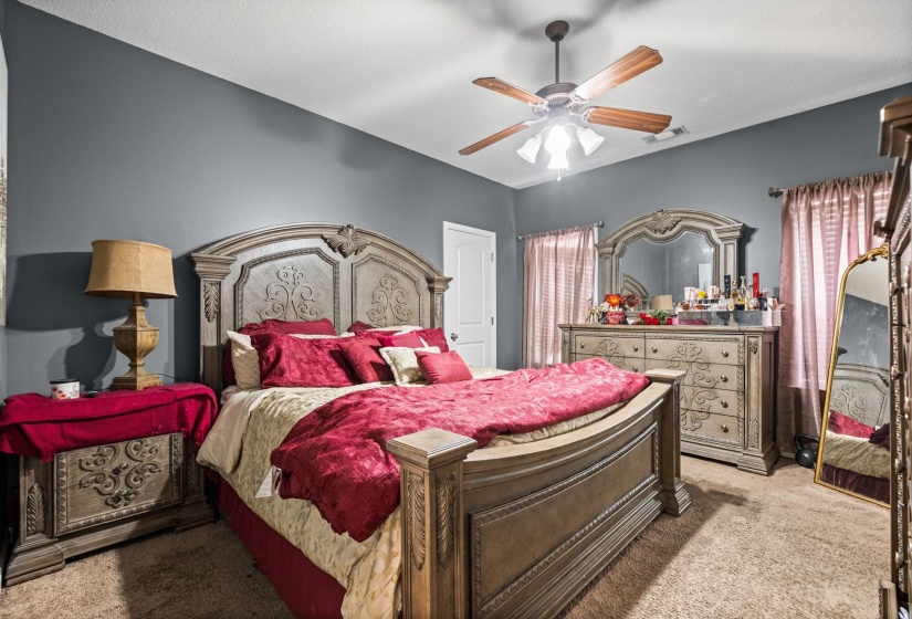 Spacious room featuring gray painted walls and a textured carpeted floor