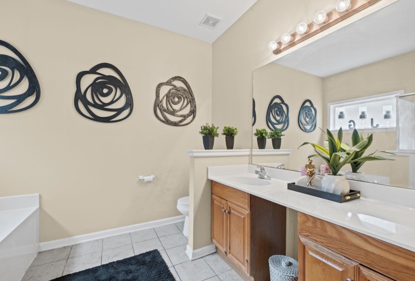 Double vanity with integrated sinks, wood-finish cabinetry, and a full-width mirror