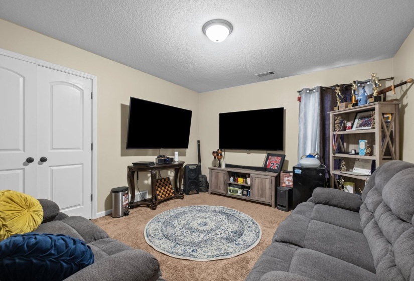 Carpeted interior space with neutral wall paint and a textured ceiling