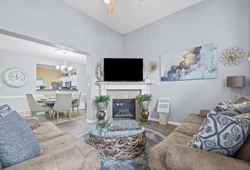 Living area featuring a vaulted ceiling and wood-finish flooring
