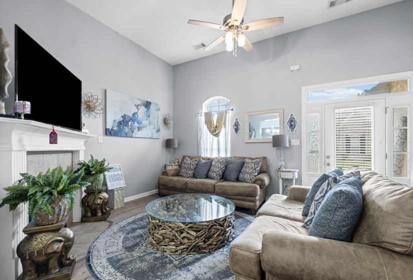 Living area featuring a vaulted ceiling and a ceiling fan with integrated lighting