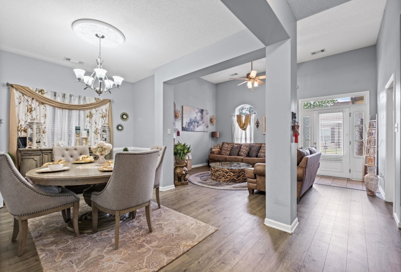 Dining area featuring wood-finish flooring, a contemporary chandelier, crown molding, and a built-in buffet