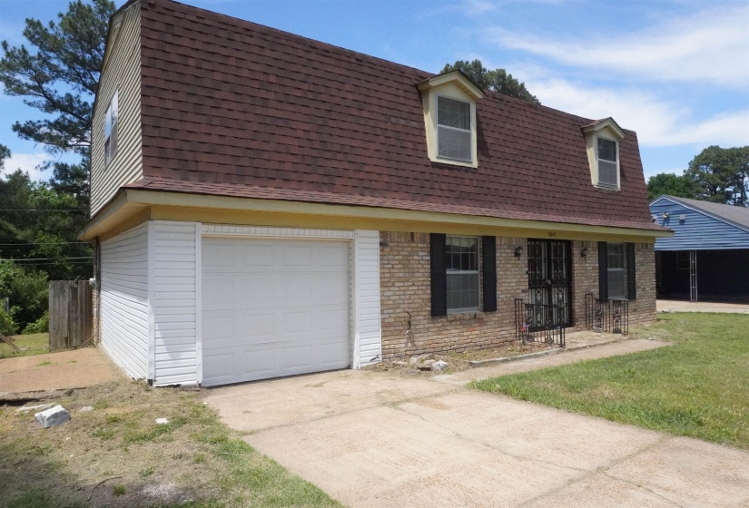 Brick and siding exterior with a red shingle roof and two dormer windows