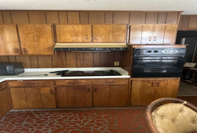 Kitchen featuring ample wood cabinetry, a built-in oven, and a cooktop range