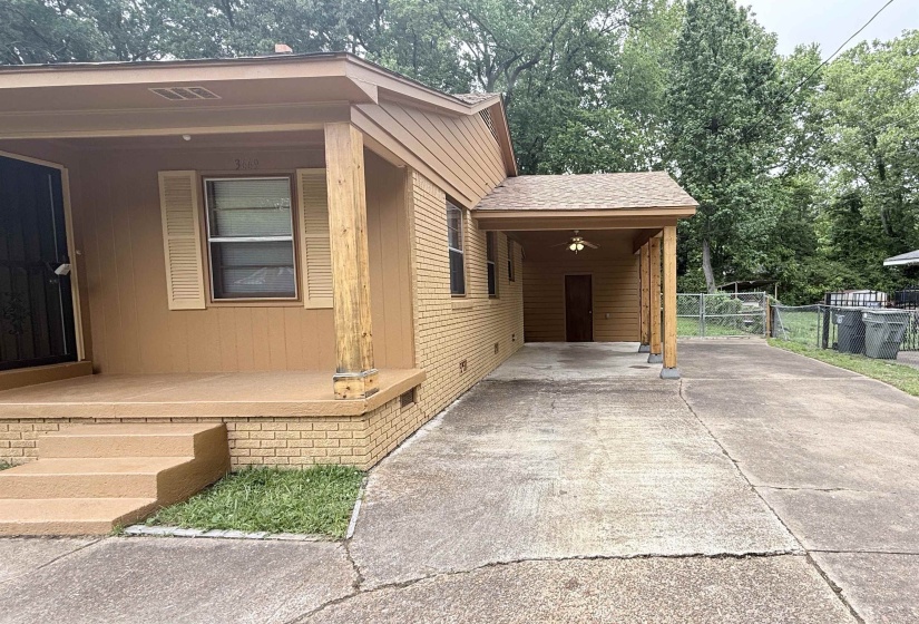Exterior featuring a covered front porch with wood columns, tan siding, and a brick foundation