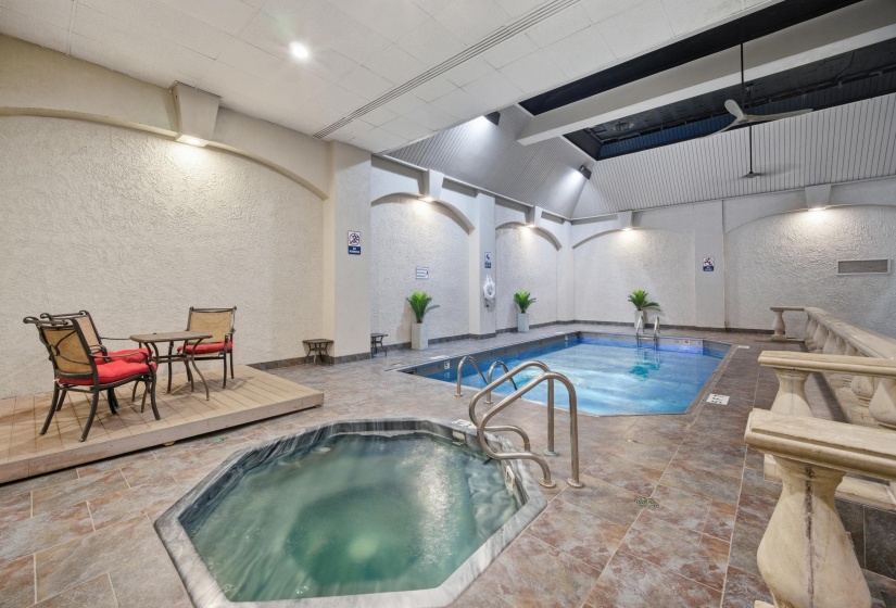 Indoor aquatic area featuring a rectangular swimming pool and an octagonal hot tub