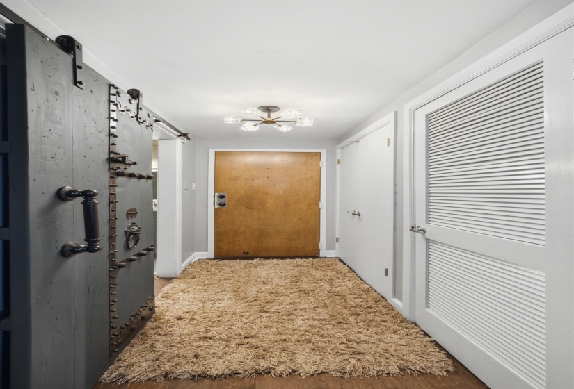 Entryway featuring wood-finish flooring, a contemporary semi-flush mount light fixture, and a solid wood entry door