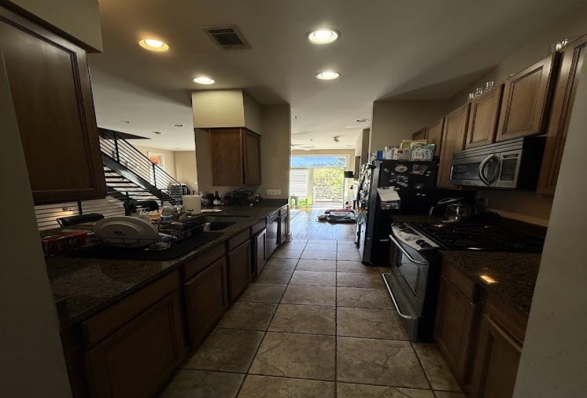Kitchen featuring stainless steel appliances, dark stone countertops, recessed lighting, and light tile patterned floors