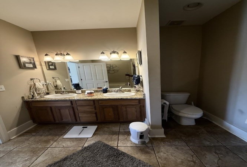 Full bathroom with double vanity and light tile patterned floors