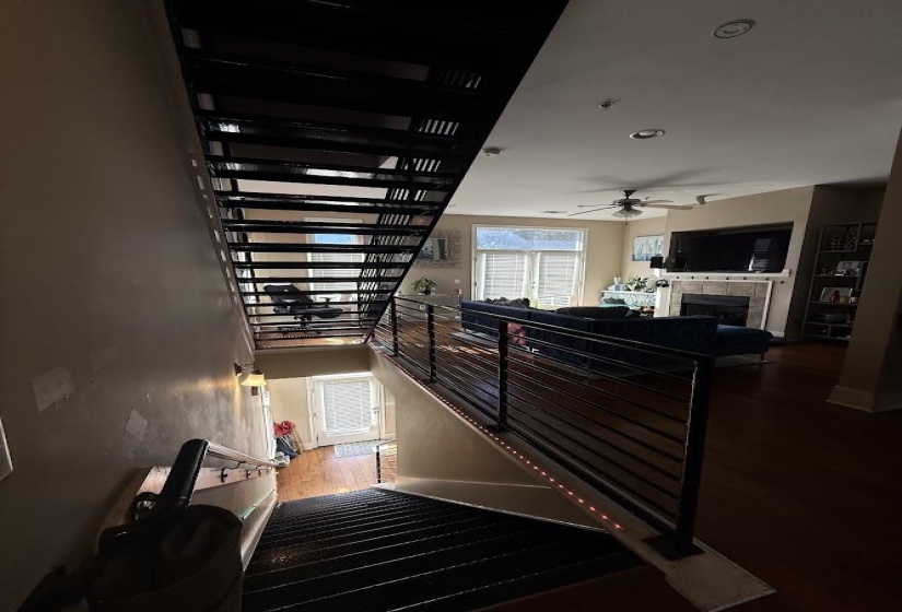 Stairs featuring a fireplace, wood finished floors, recessed lighting, and a ceiling fan