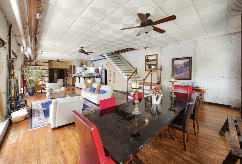 Dining space featuring ceiling fan, wood finished floors, stairs, and baseboards