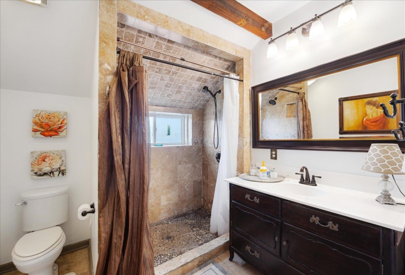 Full bathroom featuring vanity, toilet, and a tile shower