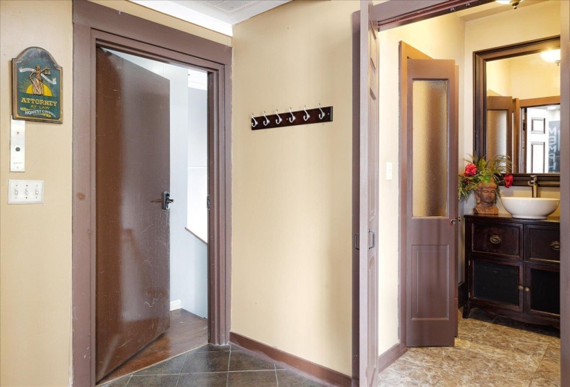 Hallway with a sink, tile patterned floors, and baseboards