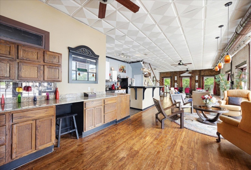 Kitchen featuring a ceiling fan, wood finished floors, brown cabinets, and light countertops
