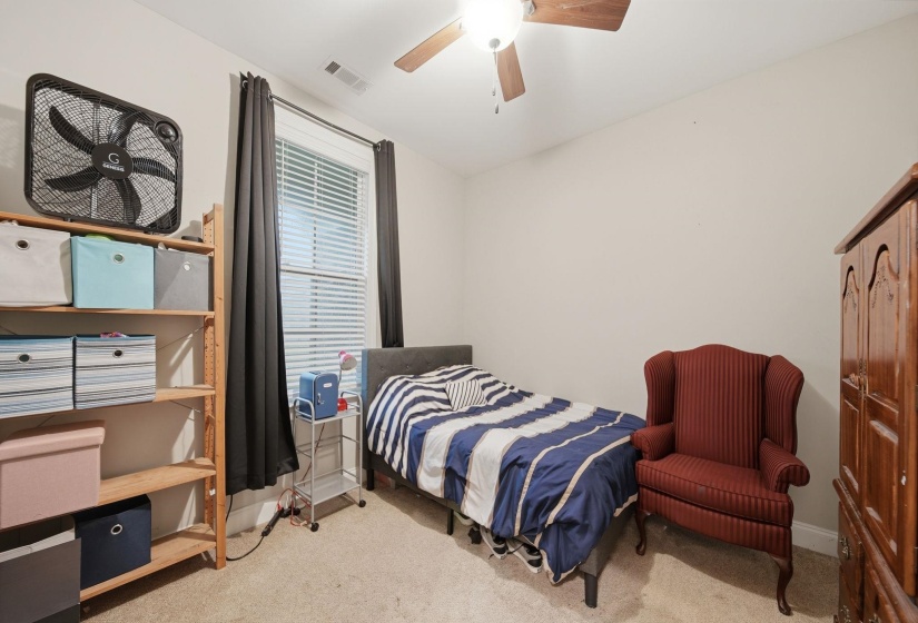 Room featuring neutral wall paint, carpet flooring, a window with blinds, and a ceiling fan with light fixture