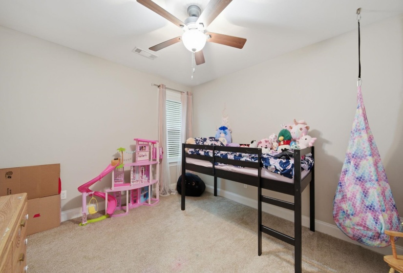 Carpeted room featuring a ceiling fan with light fixture, window with blinds, and neutral wall paint