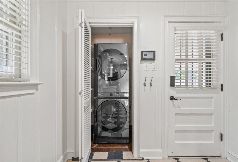 Dedicated laundry closet featuring a stacked washer and dryer unit
