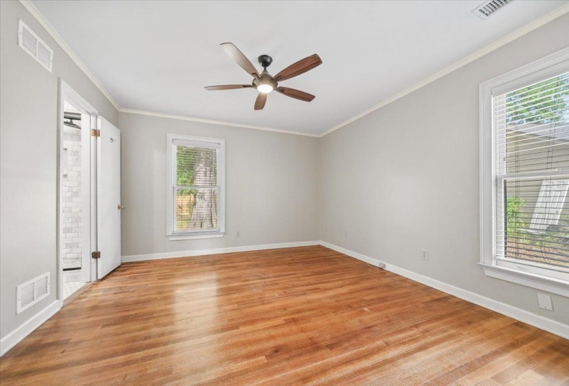 Bedroom featuring wood-finish flooring, light gray walls, and crown molding
