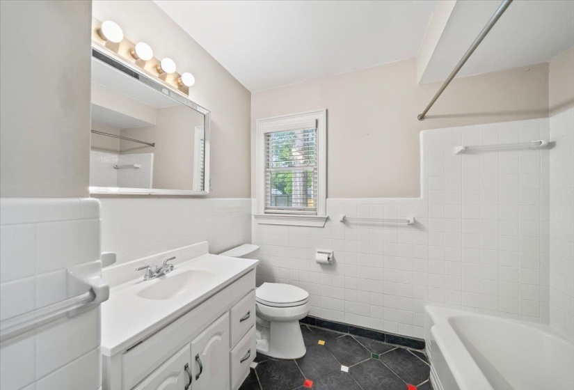 Bathroom featuring a white vanity with integrated sink, chrome faucet, and mirrored medicine cabinet