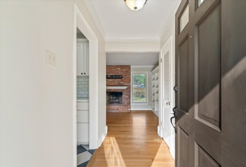 Entryway featuring a paneled front door, wood-finish flooring, and crown molding