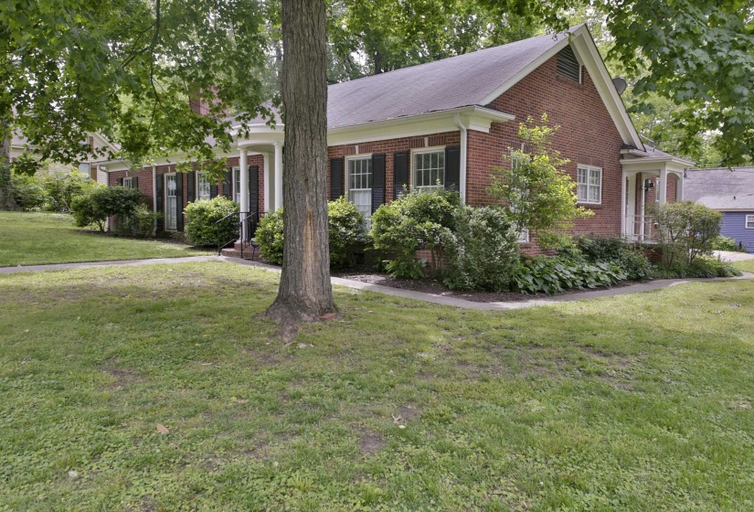 Brick exterior with white trim, featuring multiple windows with dark shutters