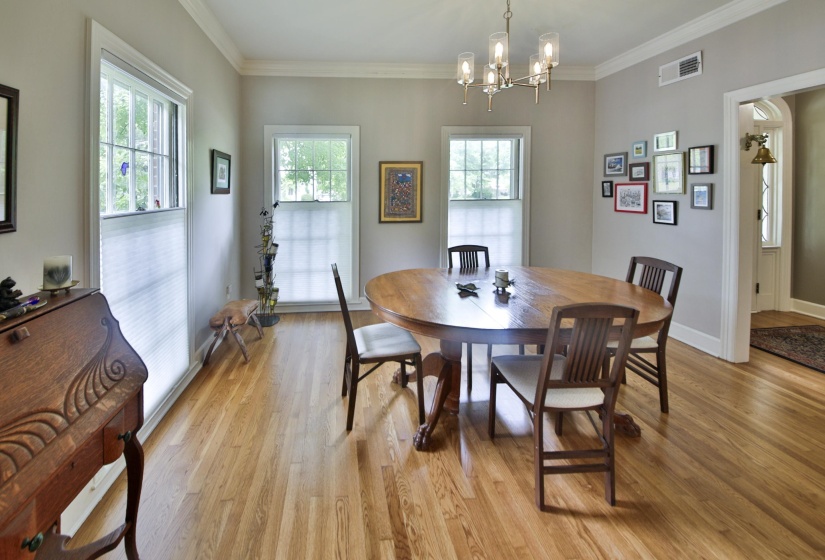 Dining area with wood-finish flooring, crown molding, and two large windows
