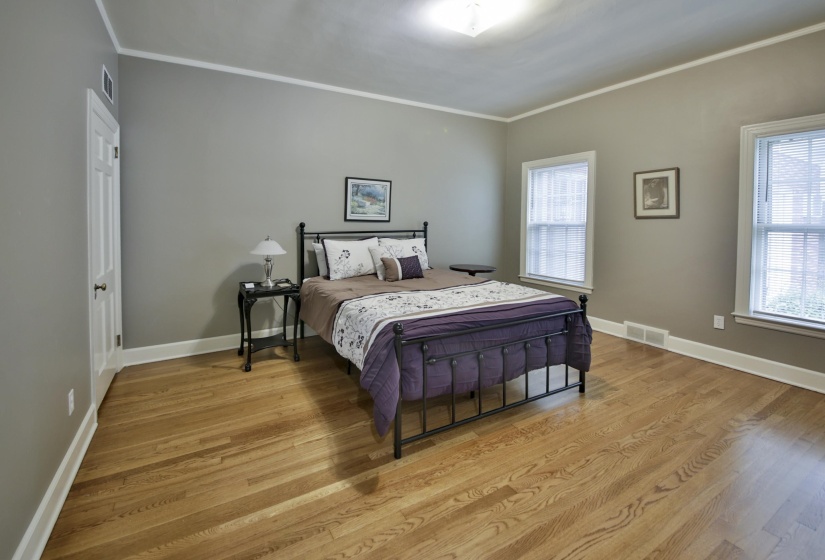 Light wood-finish flooring with white baseboards and crown molding