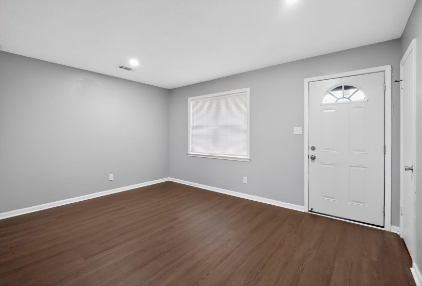 Entryway featuring wood-finish flooring, light gray wall tones, and white baseboards