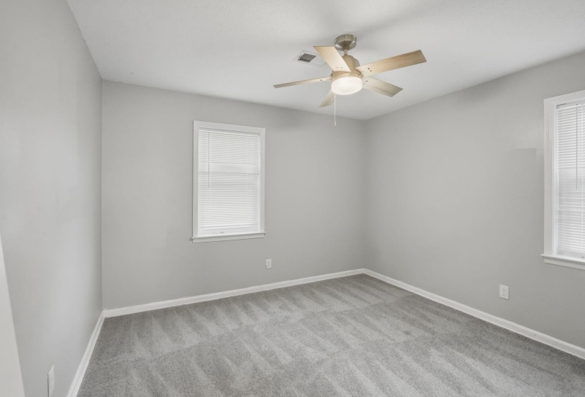 Carpeted room with light grey walls, white trim, and a ceiling fan with integrated lighting