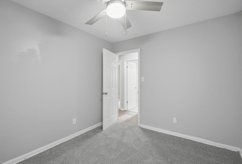 Carpeted room with light grey walls and white trim