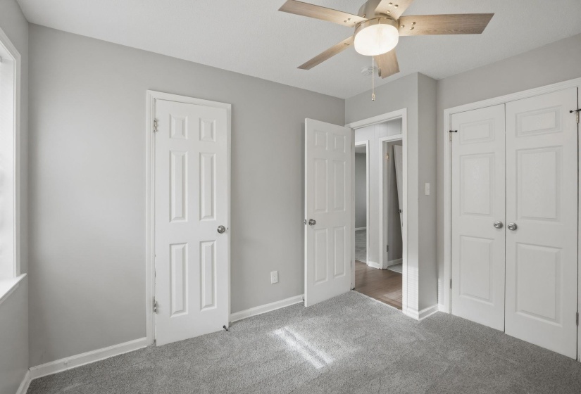 Light gray walls with white trim and gray carpeting