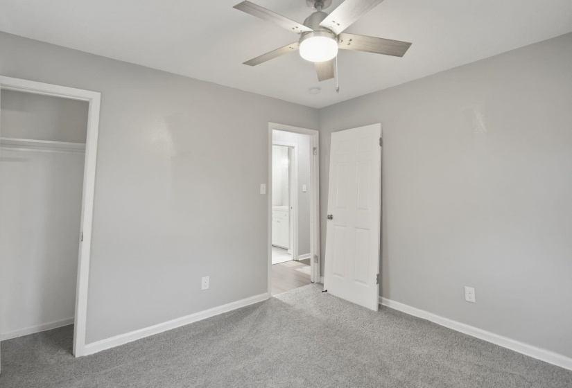 Room featuring light gray walls, gray carpet flooring, and white trim