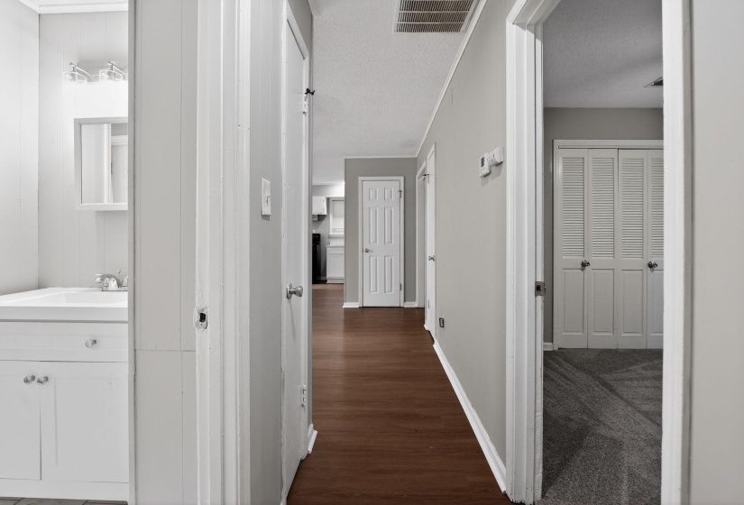 Hallway featuring wood-finish flooring, light gray wall paint, and white trim