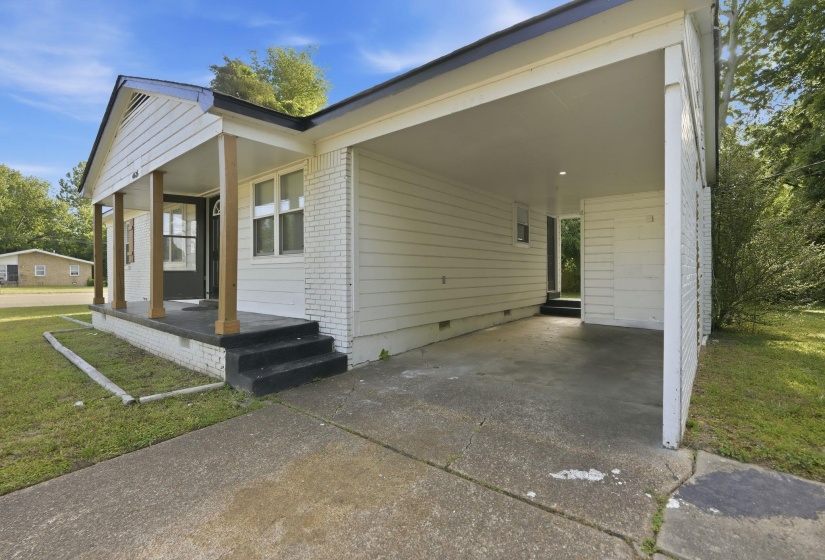White exterior siding with brick accents and a covered front porch featuring wooden support columns