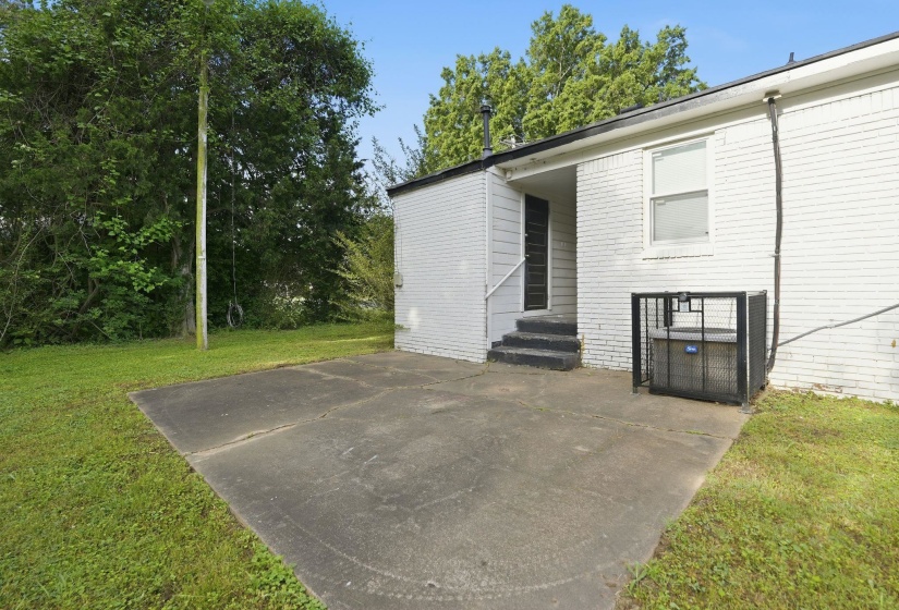 Concrete patio extending from the white brick exterior