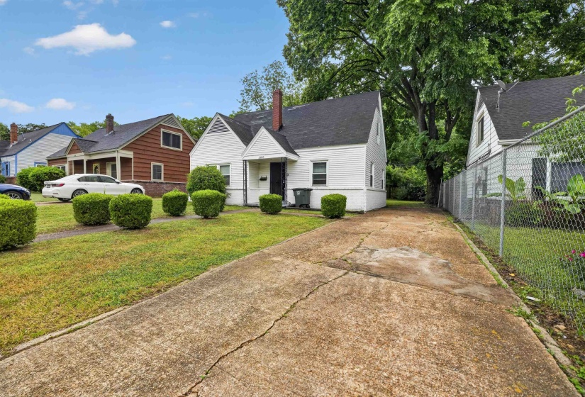 White exterior residence with a dark roof and a concrete driveway