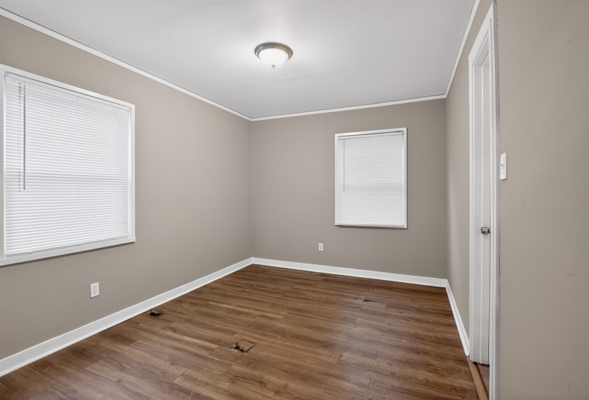 Room featuring wood-finish flooring, neutral wall paint, and white trim