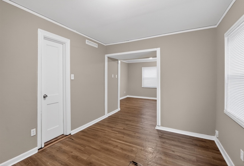 Interior room with wood-finish flooring, neutral wall paint, and white trim