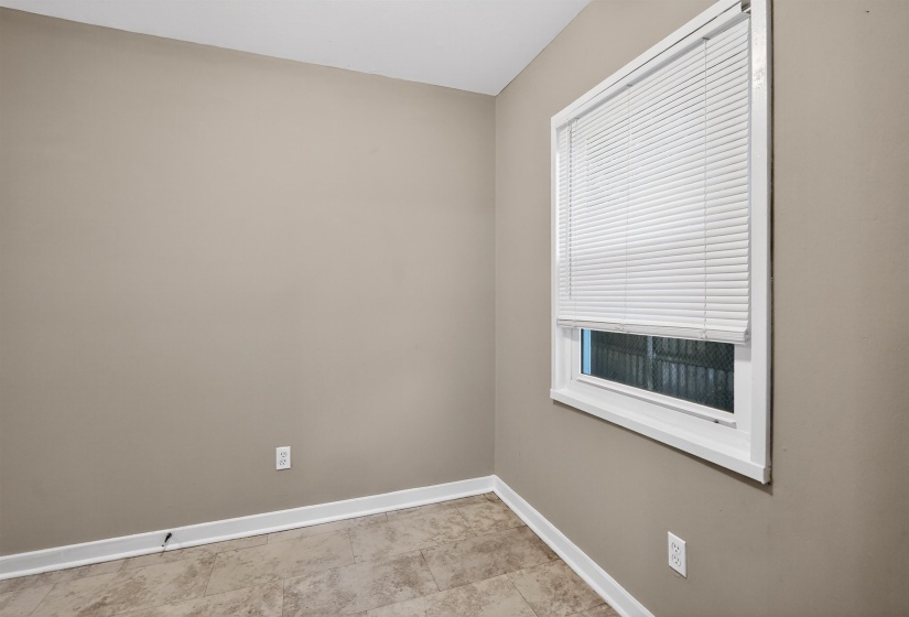 Neutral tone wall finish, white trim, and patterned tile flooring