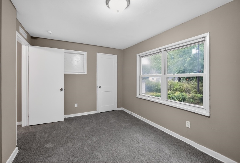 Room featuring new gray carpeting, neutral-toned walls, and white trim