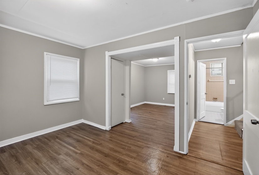 Interior space featuring wood-finish flooring, light gray walls, and white trim