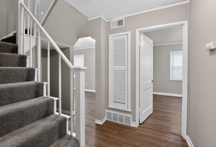 Carpeted staircase with white balusters and handrail
