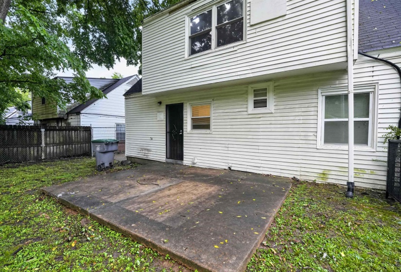 Rear concrete patio area with a privacy fence