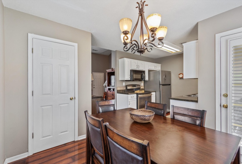 Dining area featuring a wood-finish table, a decorative chandelier, and wood-finish flooring